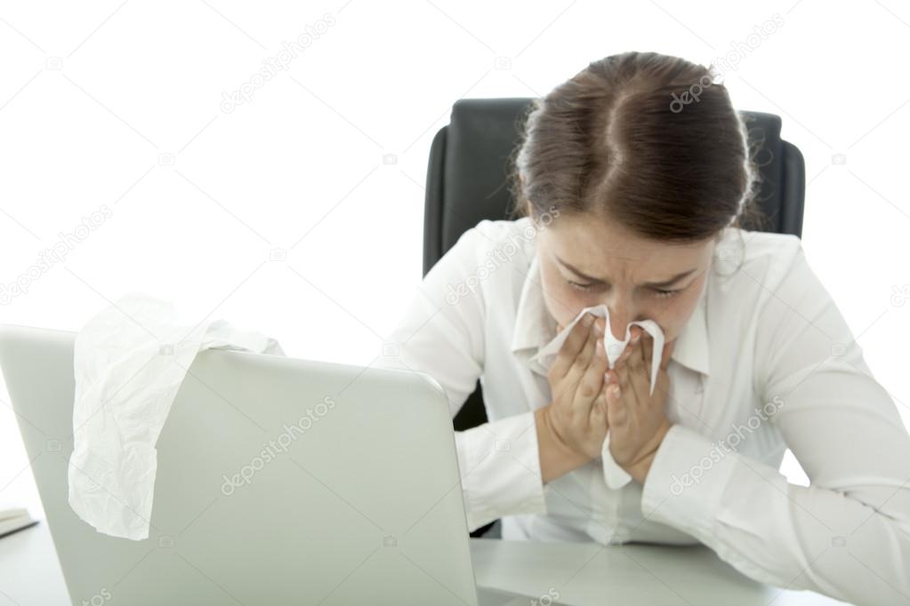 young brunette business woman is ill with hankies behind her laptop