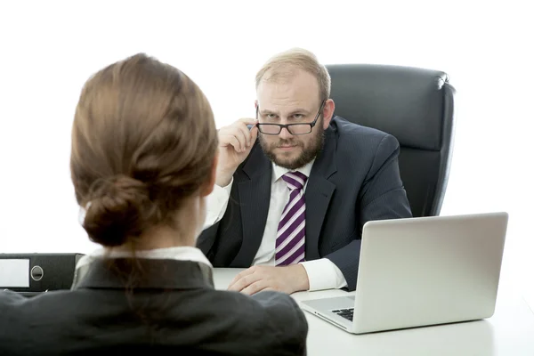 Skägg business man brunett kvinna vid skrivbord ser allvarligt på glasögon — Stockfoto