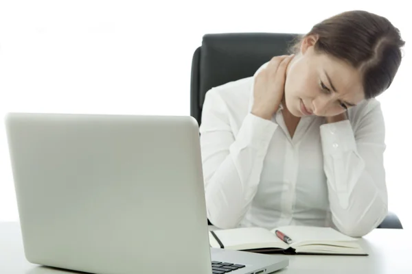 Jonge brunette zakenvrouw heeft pijn nek achter computer — Stockfoto