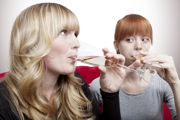 Unga vackra blonda och röda haired flickor dricka champagne på re — Stockfoto