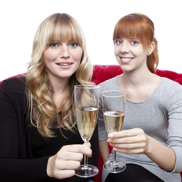 Giovani belle ragazze bionde e rosse con champagne sul rosso — Foto Stock