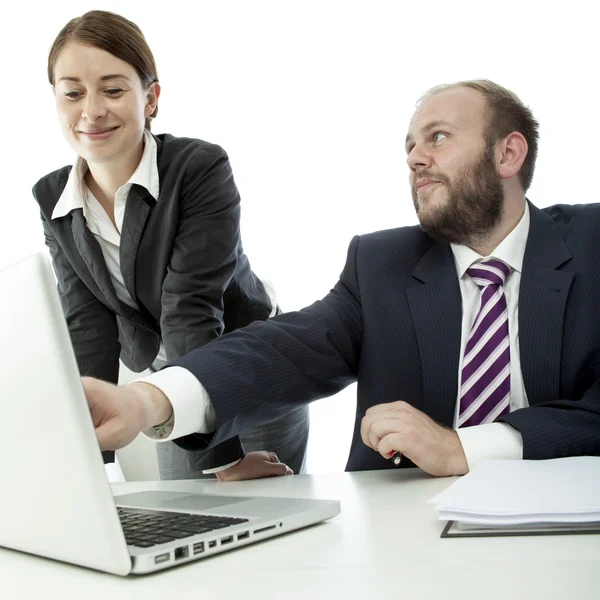 Beard business man brunette woman at desk point laptop Stock Image