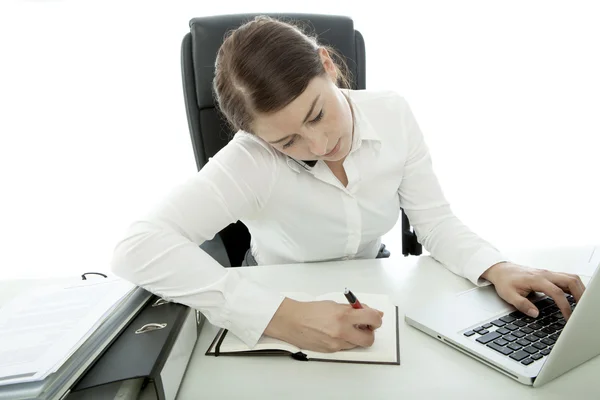 Unga brunett affärskvinna är upptagen med telefon och laptop — Stockfoto