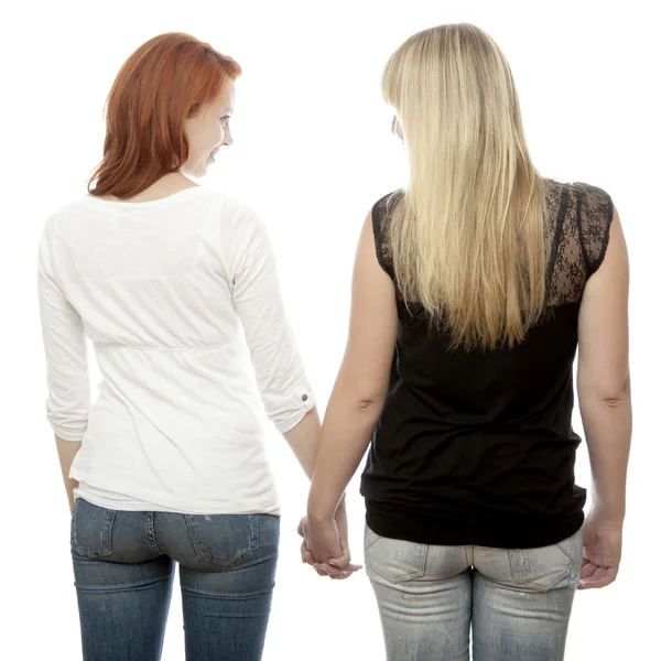 Young beautiful red and blond haired girls holding hands back — Stock Photo, Image