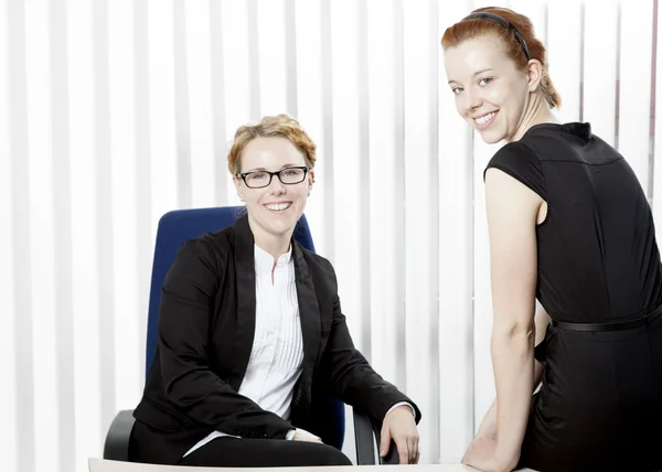 Two happy young women in an office — Stock Photo, Image