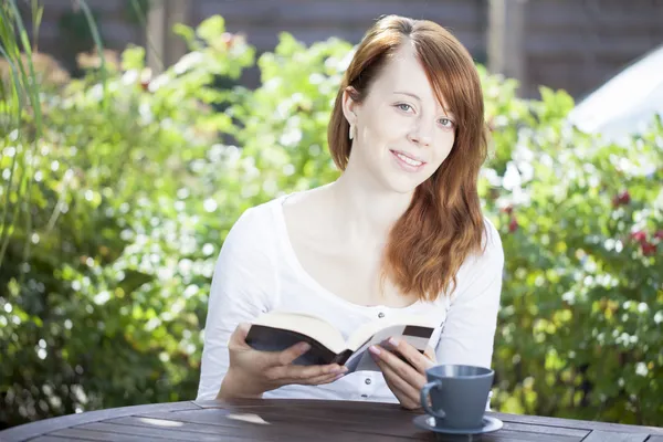 Hübsche junge Frau liest draußen — Stockfoto