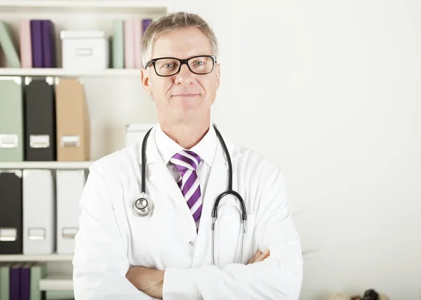 Dokter met stethoscoop om zijn nek kijkend naar de camera — Stockfoto