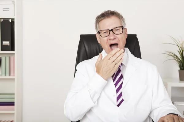 Gäspningar medelålders manliga läkare — Stockfoto