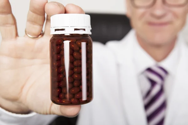 Doctor holding an unlabeled bottle of tablets — Stock Photo, Image
