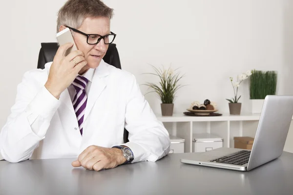 Doctor charlando en su teléfono móvil — Foto de Stock