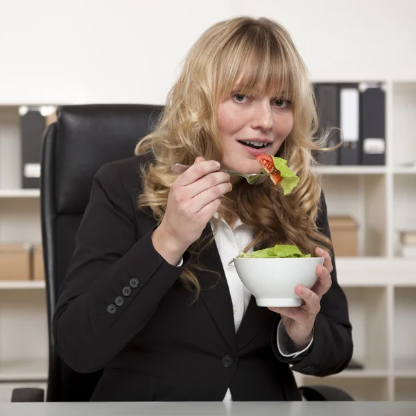 Улыбающаяся деловая женщина наслаждается здоровым салатом — стоковое фото