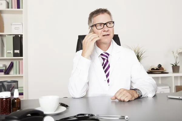 Mannelijke arts aanvragende client via telefoon — Stockfoto
