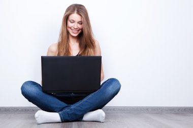 laptop ile katta oturan güzel genç kadın