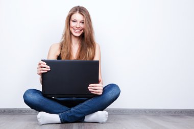 beautiful young woman sitting on the floor with laptop