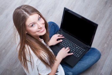 laptop ile katta oturan güzel genç kadın