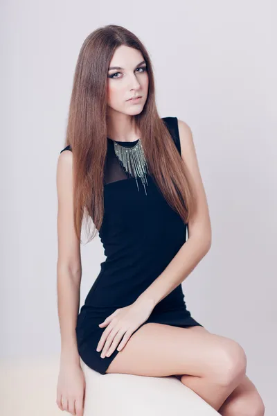 Portrait of beautiful brunette young woman on couch — Stock Photo, Image