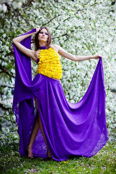 Belle femme dans une jupe fluide parmi les pommiers en fleurs — Photo