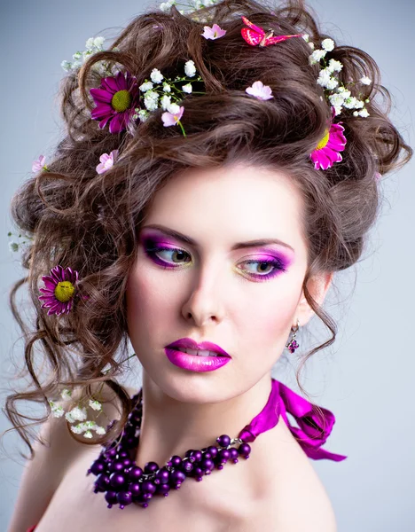 Όμορφη κοπέλα με λουλούδια στα μαλλιά και φωτεινό μακιγιάζ — Φωτογραφία Αρχείου