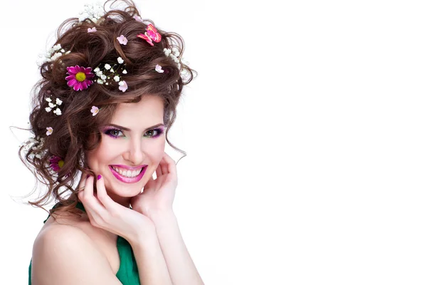 Heureuse jeune femme avec des fleurs dans ses cheveux et un maquillage lumineux iso — Photo