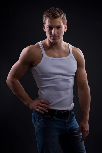 Sexy young man wearing white undershirt and jeans — Stock Photo, Image