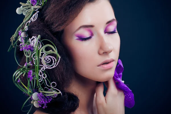 Schönheit Mädchen mit Orchideenblüten und professionellem Make-up — Stockfoto