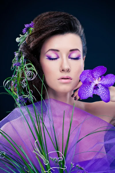 Menina de beleza com flores de orquídea e maquiagem profissional — Fotografia de Stock