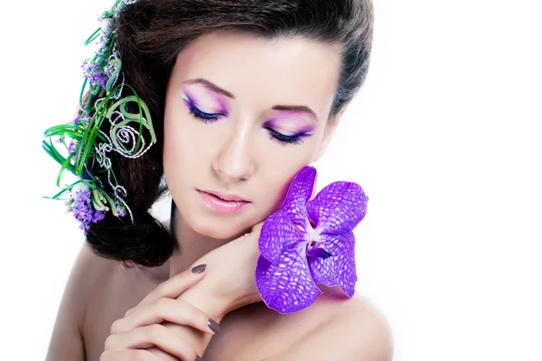 Menina de beleza com flores de orquídea e maquiagem profissional — Fotografia de Stock