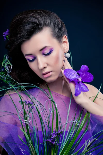 Menina de beleza com flores de orquídea e maquiagem profissional — Fotografia de Stock