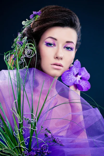 Fille de beauté avec des fleurs d'orchidée et maquillage professionnel — Photo