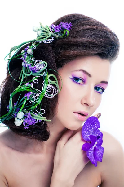 Schönheit Mädchen mit Orchideenblüten und professionellem Make-up — Stockfoto