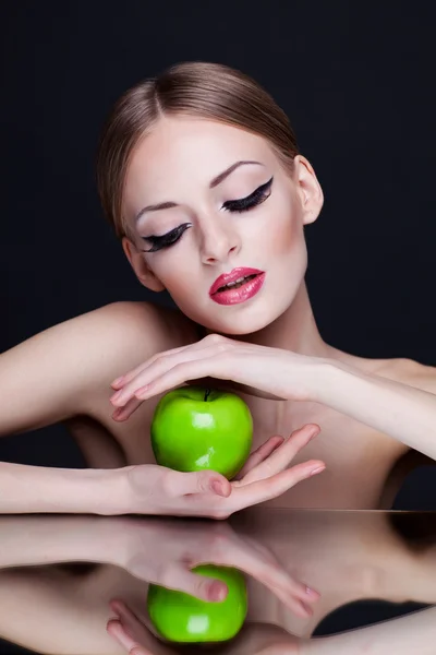 Unga skönhet kvinna med grönt äpple på mörk bakgrund — Stockfoto