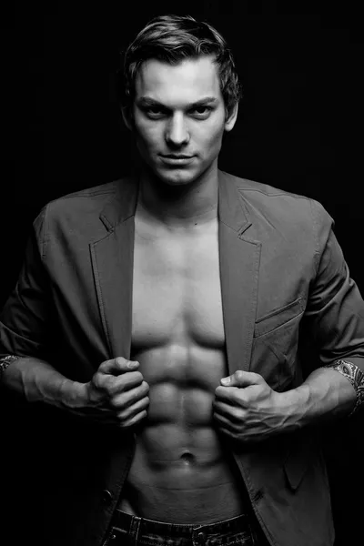 Black and white portrait of sexy man with open jacket over dark — Stock Photo, Image