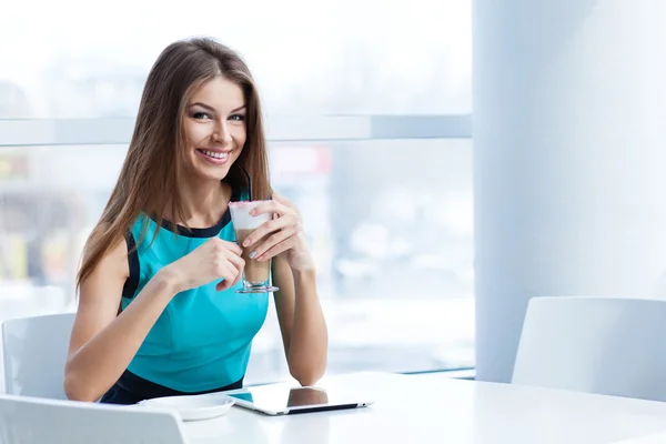 Молодая счастливая женщина с планшетным компьютером в кафе — стоковое фото