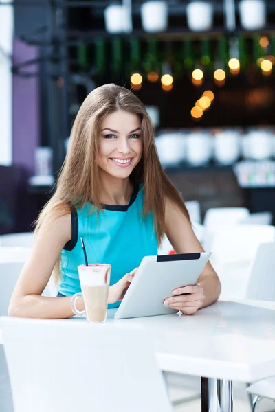 Mujer feliz joven usando tableta en un café — Foto de Stock