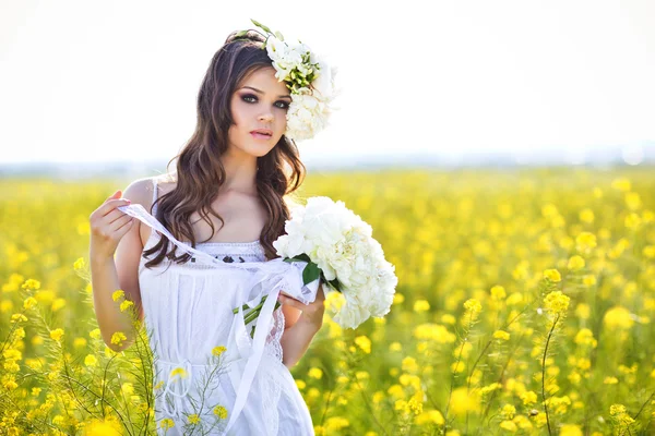 Saçında çiçekler ile yaz alanında genç güzel kadın — Stok fotoğraf