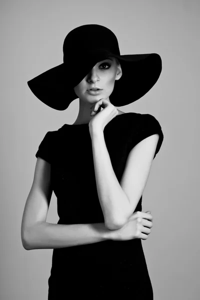 High fashion portrait of elegant woman in black and white hat and dress ...