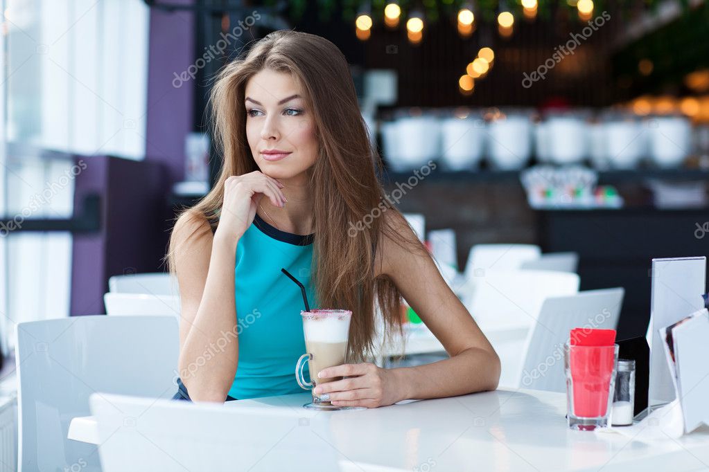 Portrait of a beauty young woman sitting in a coffe shop