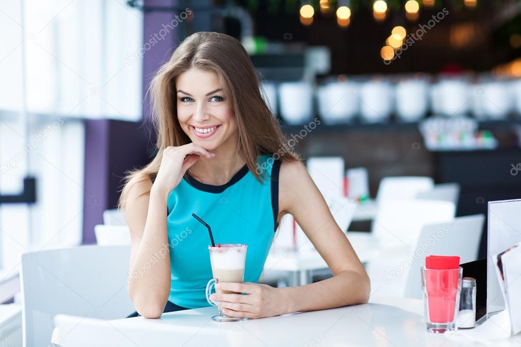 Portrait of a beauty young woman sitting in a coffe shop