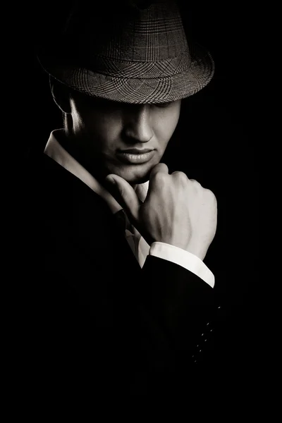 Низкий ключ портрет молодого гангстера в шляпе в темноте . — стоковое фото