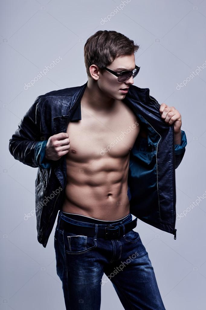 Young handsome macho man in sunglasses with open leather jacket Stock Photo by ©MaxFrost 40531937
