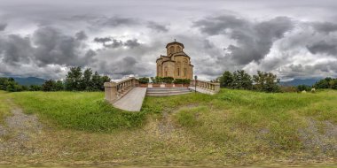 Sarı tuğlalı ortodoks Gürcü kilisesi yakınlarında 360 hdri panorama. Bulutlu bir günde yüksek dağlarda, eş dikdörtgen şeklindeki küresel projeksiyonda. VR AR içeriği 