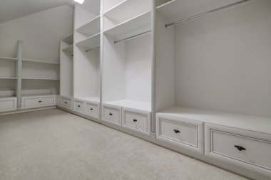 Modern apartman ya da otel odasındaki boş gardıropta raflar ve elbiseler asılıdır.