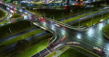Otobanda farları yanan arabalarla ve çok katlı binaların camlarında ışıkla kavşak kavşağındaki gece kaçamağı. Büyük şehirde hayat. Işık serenadı ve trafiğe tepeden bakmak
