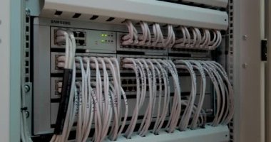 Modern sunucuda çok sayıda kablo ve kablo ve ağ ekipmanı yanıp sönen yeşil ışıklar ve veri merkezinde raftaki optik kesiciler