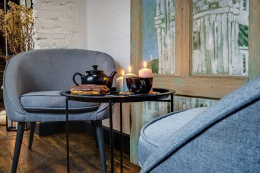 comfortable chairs and table with flowers  in interior the modern living room 