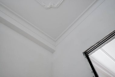 Tavanın köşesi, karman çorman kartonpiyerle kaplı.. 