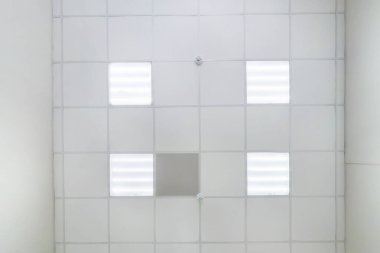 kaset asılmış tavanda kare halojen benekli lambalar ve boş bir oda ya da evde alçıpan inşaatı. Gergin tavan beyaz ve karmaşık şekil. Manzaraya bakıyorum