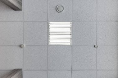 kaset asılmış tavanda kare halojen benekli lambalar ve boş bir oda ya da evde alçıpan inşaatı. Gergin tavan beyaz ve karmaşık şekil. Manzaraya bakıyorum