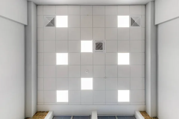 カセットは アパートや家の空の部屋で正方形のハロゲンスポットランプと乾式壁の建設と天井を中断しました 天井の白と複雑な形状をストレッチ ビューを検索する — ストック写真