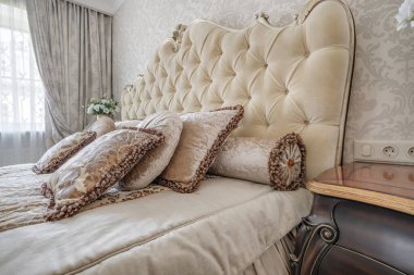 Stüdyo dairelerde açık renkli yastıklı modern lüks yatak odasının içinde.